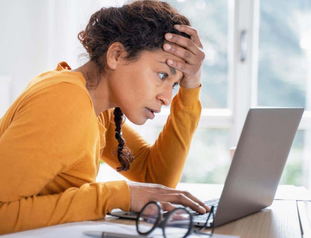 Young woman feeling stressed while looking bank account online